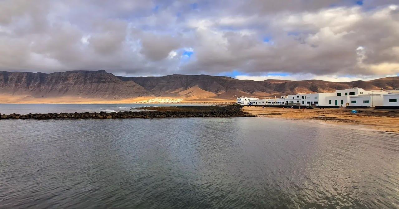 Wild golden sand under cliffs at Famara beach in northern Lanzarote