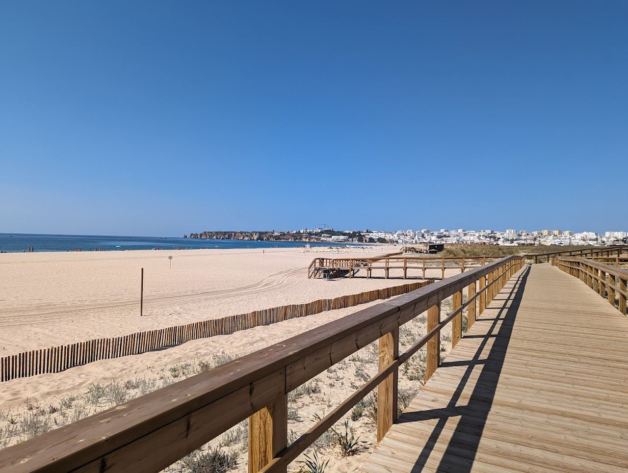 The long open sweep of sand and gentle summer water at Meia Praia in Lagos