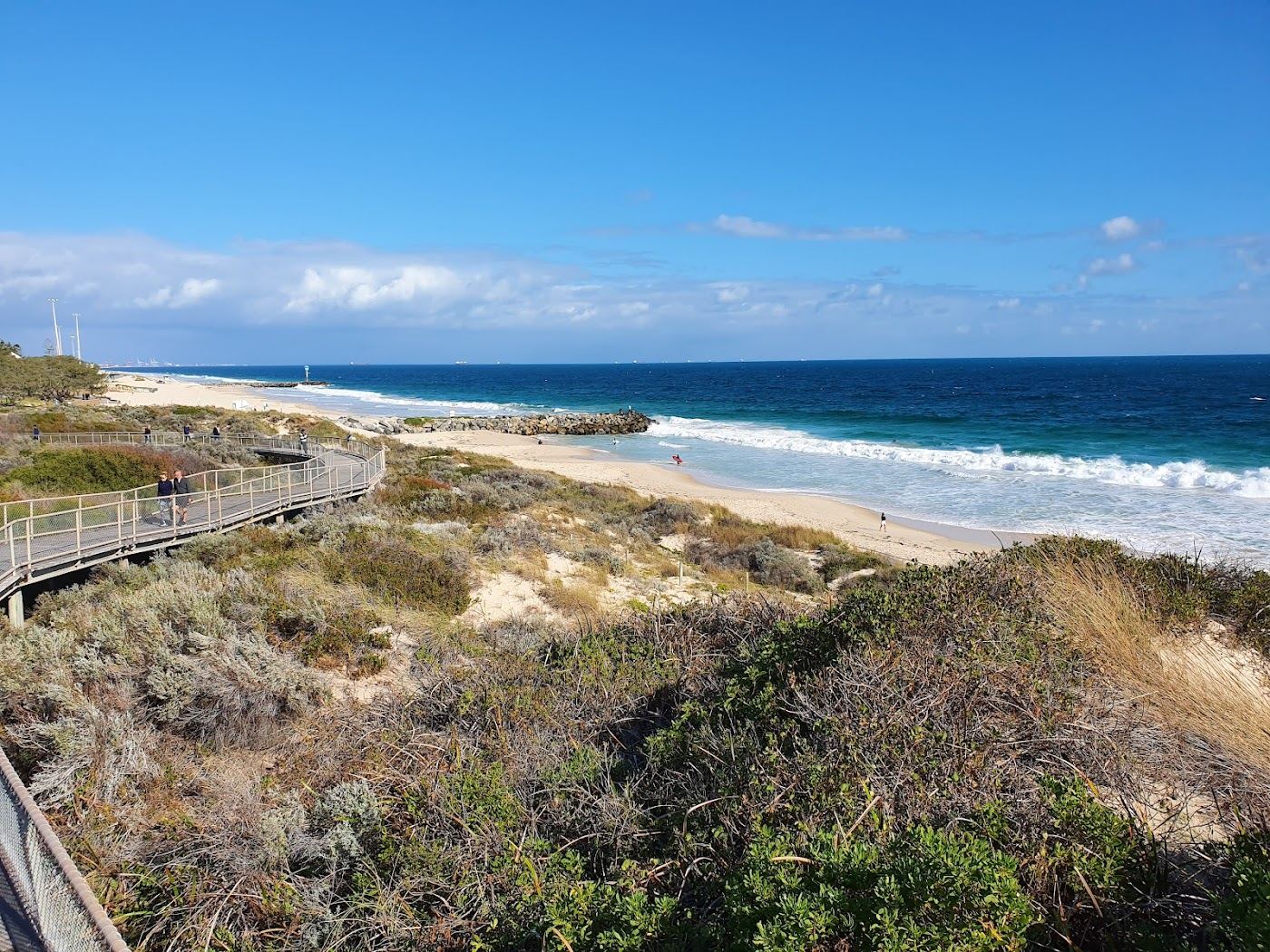The wide golden sand, low dunes and calm morning water of Floreat Beach in the western suburbs of Perth