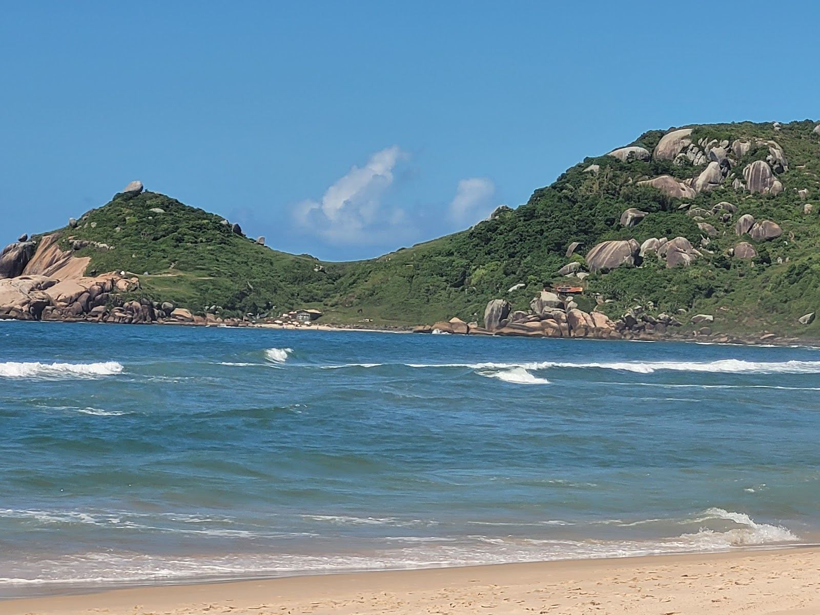 Soft pale sand and strong Atlantic surf below green headlands at Praia Mole on the east coast of Florianopolis Brazil