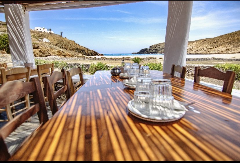 The simple seaside setting of Fokos Taverna on the sand at Fokos Beach on Mykonos