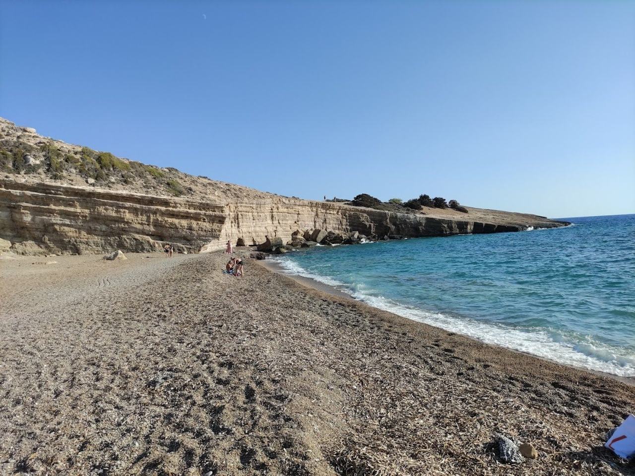 The clear water, boulders and tall cliffs around the remote cove of Fourni near Monolithos on the west coast of Rhodes
