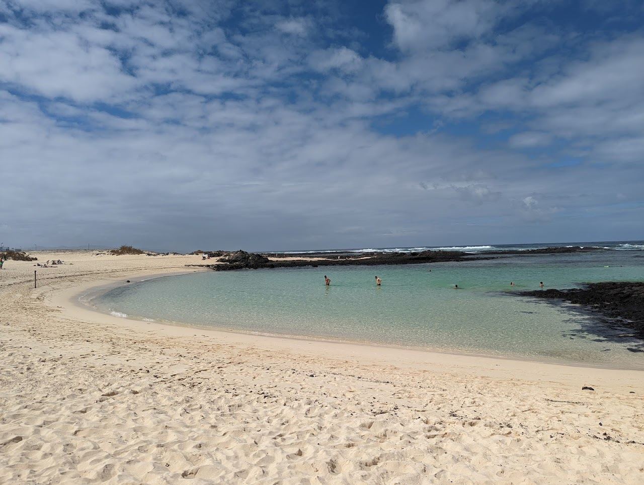 Turquoise lagoon and pale sand glowing at sunset near the fishing town of El Cotillo in Fuerteventura