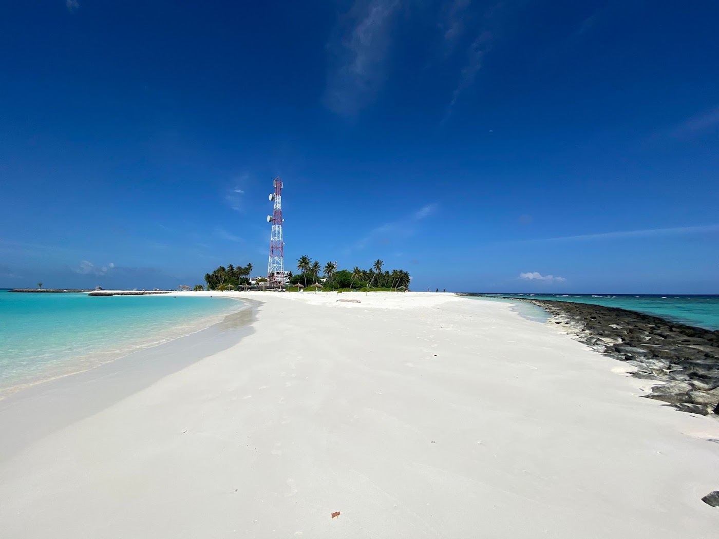 Palms and a quiet shallow lagoon on the bikini beach at Fulidhoo in the Maldives