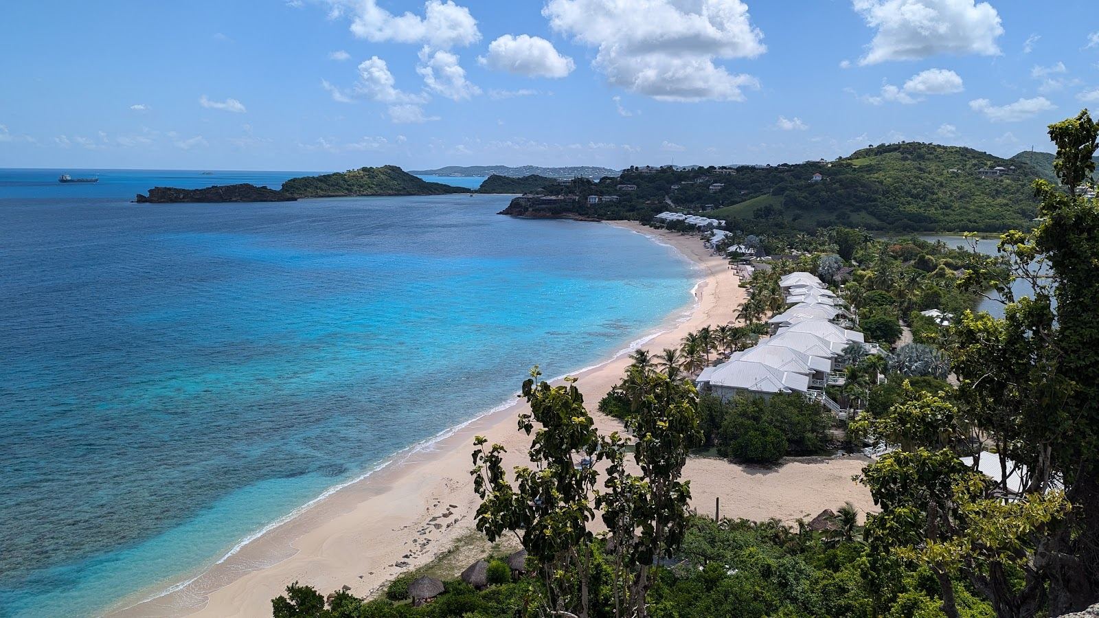 The long quiet sand and open Caribbean water of Galley Bay in Antigua