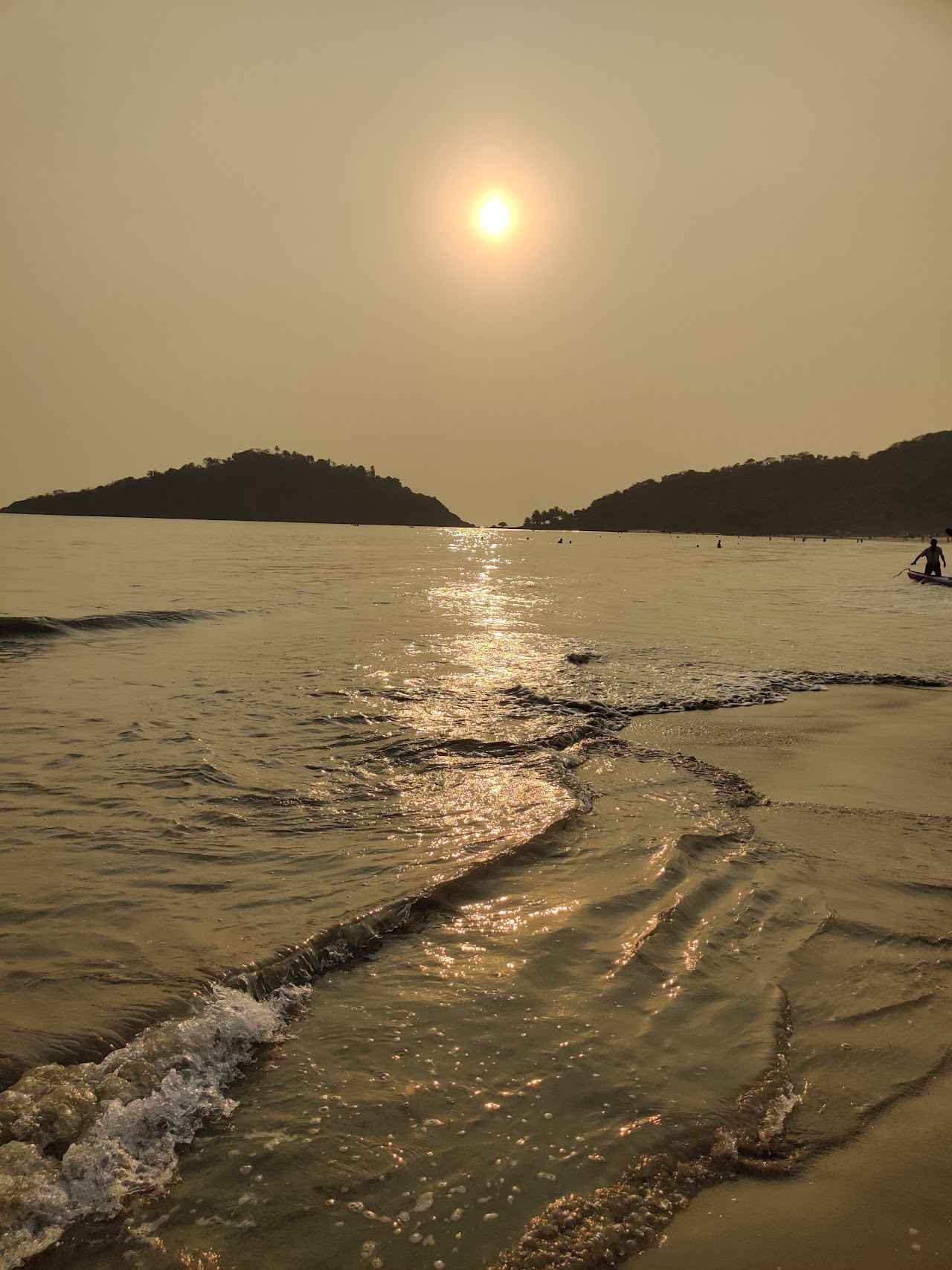 Sunset over the palm fringed curve of Palolem beach in south Goa