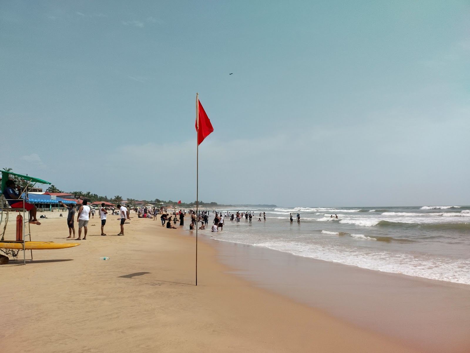 Wide pale sand and a line of shacks behind the surf at Baga Beach in North Goa