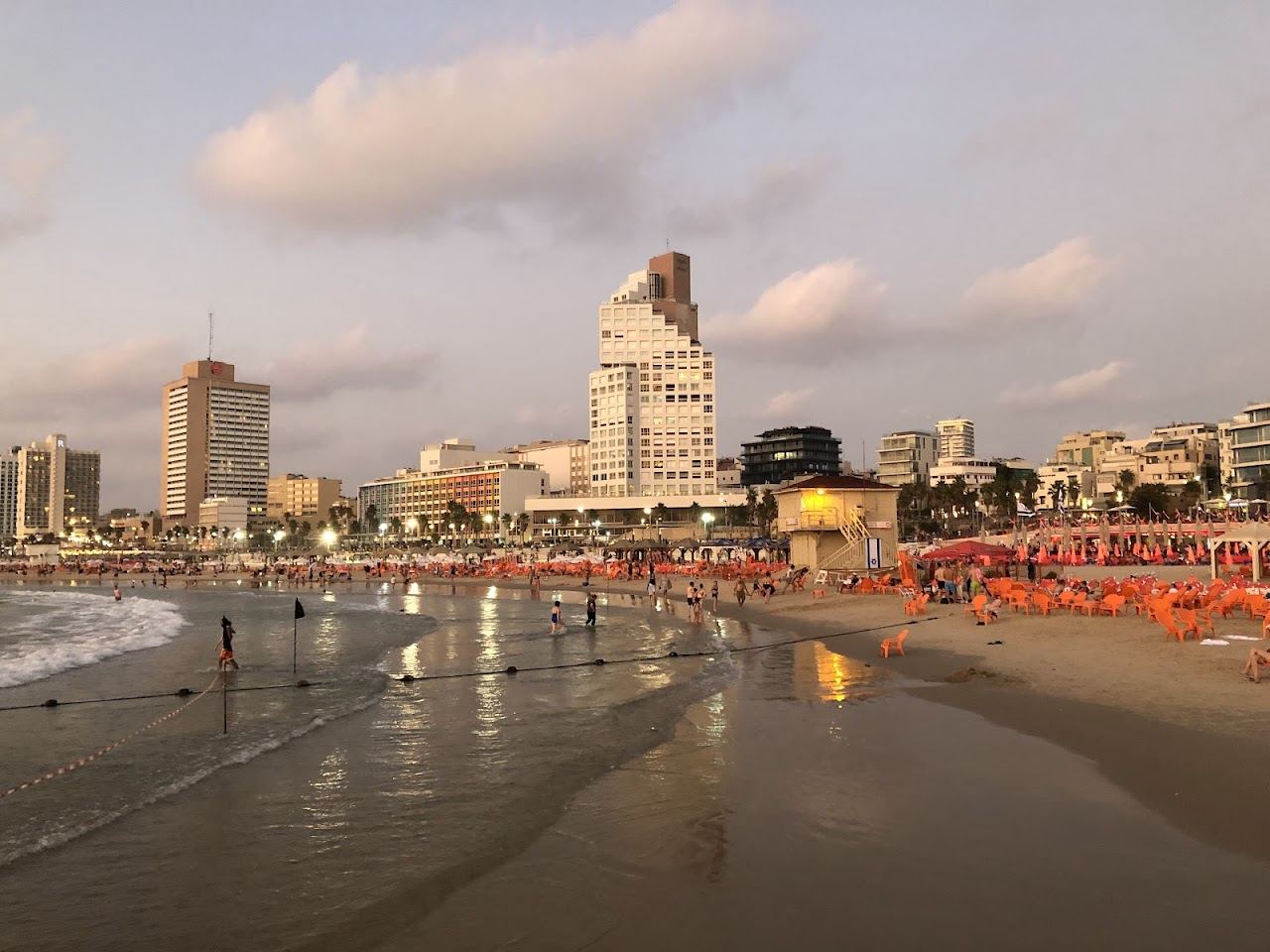 The promenade, sunbeds and soft sand of Gordon beach in Tel Aviv beside the marina