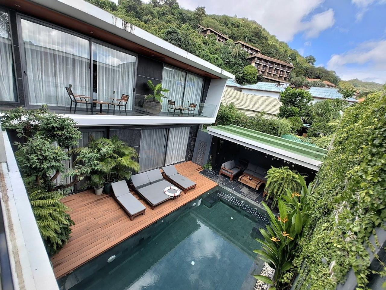 A large pool villa with room for a group above a calm bay on the coast of Phuket