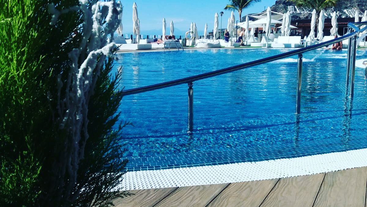 Pool and daybeds overlooking the bay at Amadores Beach Club in Gran Canaria