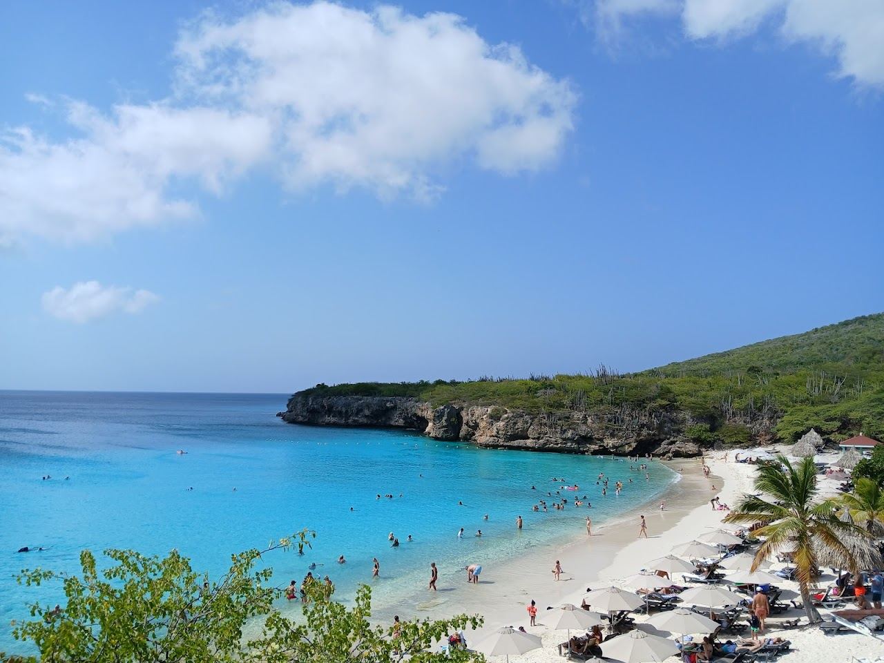 Turquoise water and pale sand framed by rocks at Grote Knip cove on Curacao