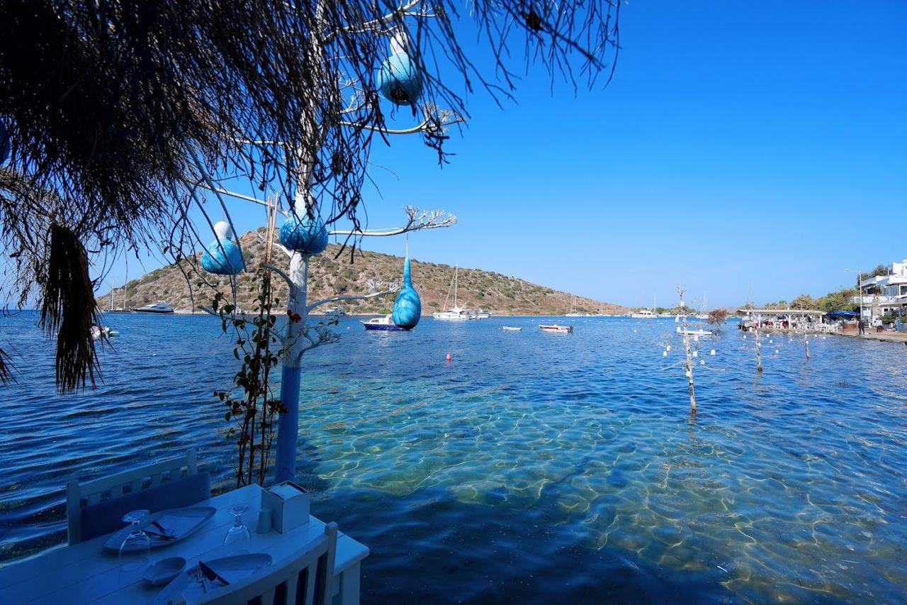 Sunset over the fish restaurants and bay at Gumusluk near Bodrum