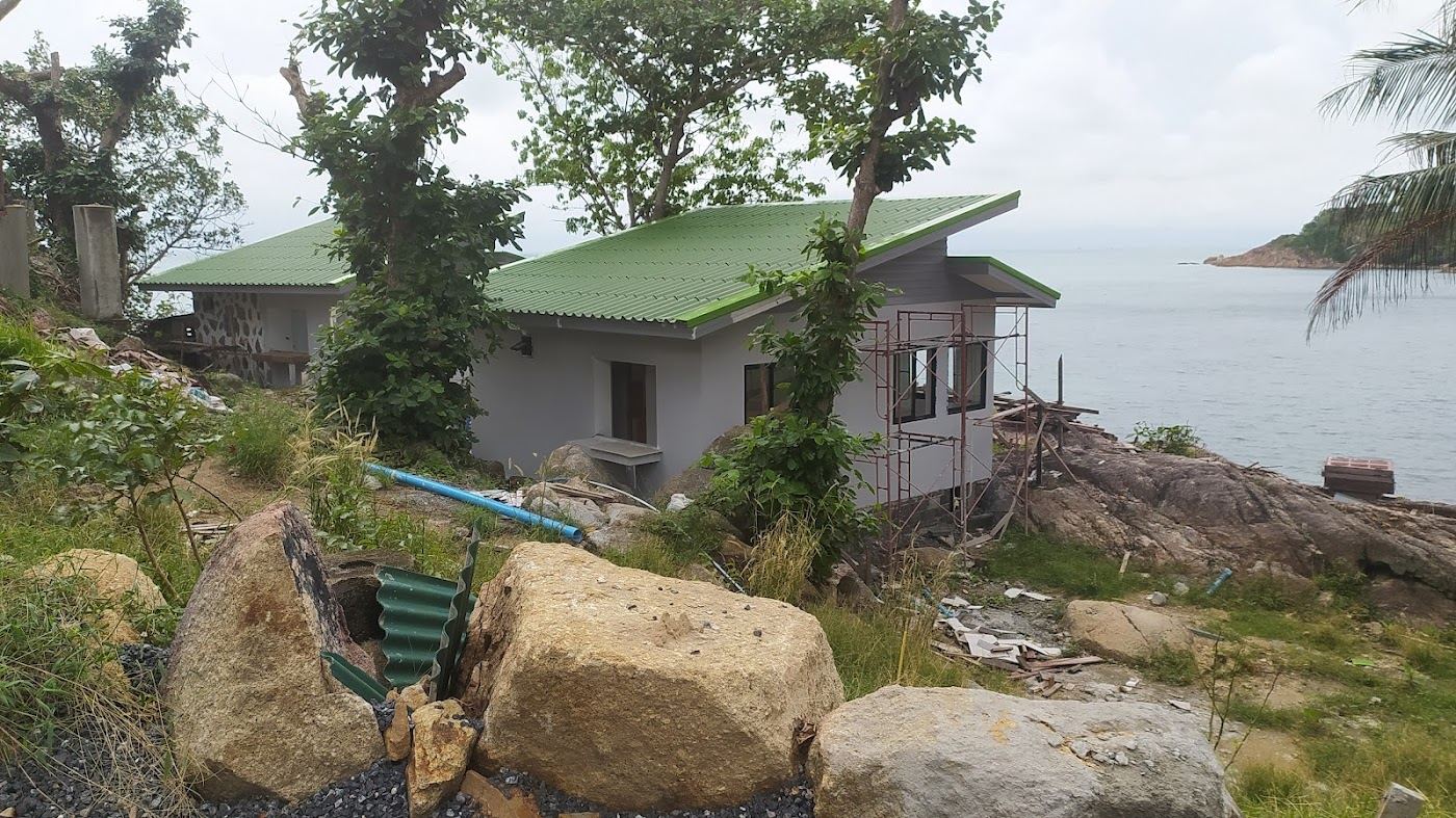 A simple bungalow beach restaurant and the coral cove at Haad Khom on the north coast of Koh Phangan