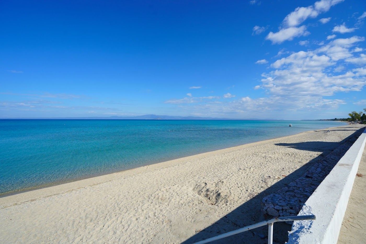 Soft sand and gentle clear shallows along the resort front at Hanioti on Kassandra in Halkidiki