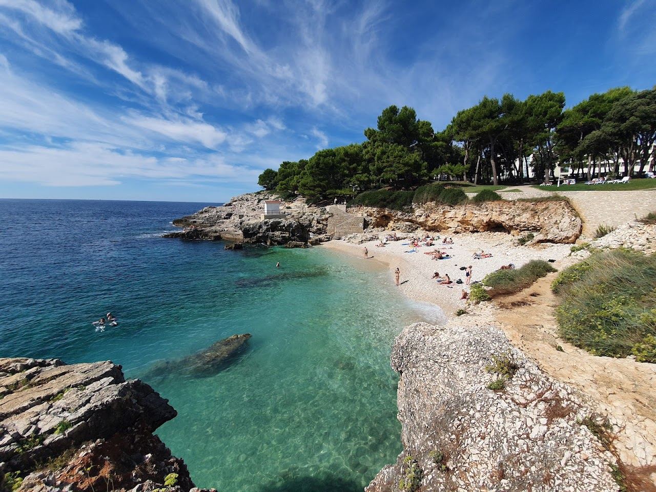 Bright turquoise water over white pebble at Hawaii beach on the Verudela peninsula near Pula