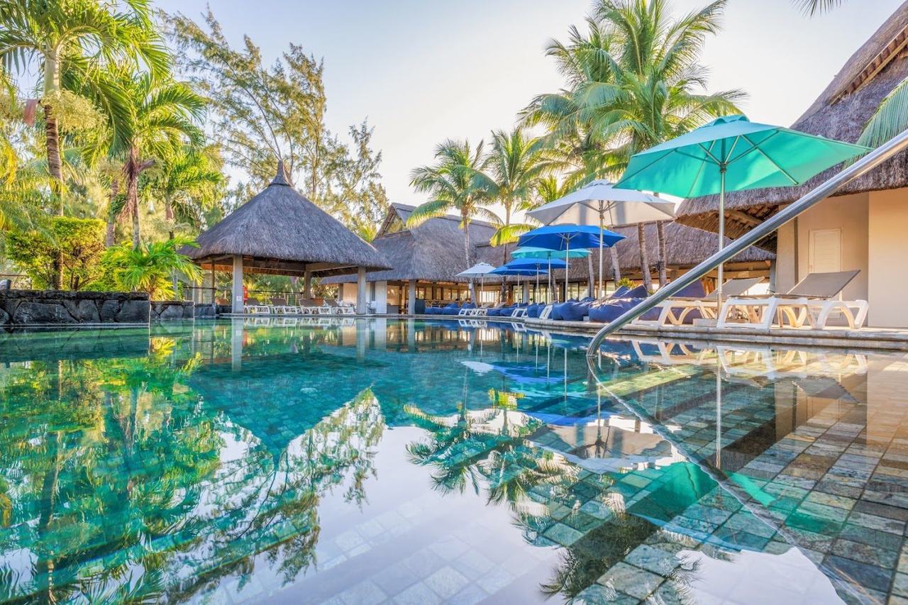 A volcanic island fringed by reef protected lagoons, with calm turquoise water, mountains inland and polished resorts.