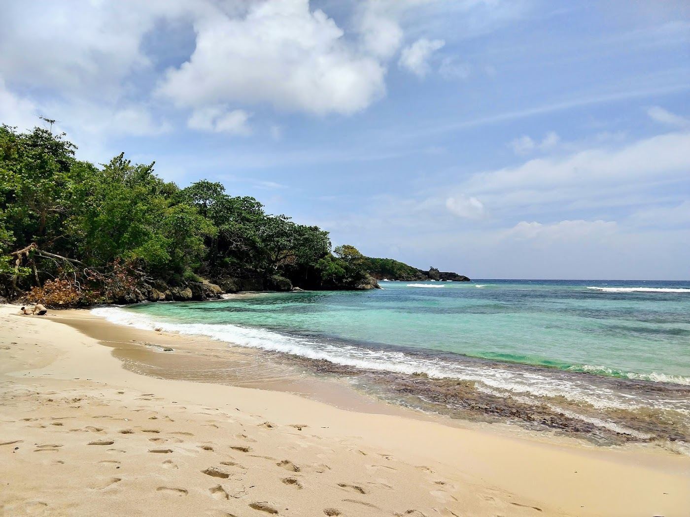 Free community beach with calm water and green hills in Jamaica