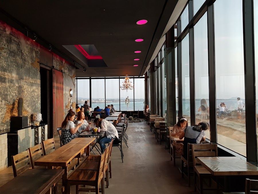 Glass walled oceanfront cafe at Monsant in Aewol on the northwest coast of Jeju