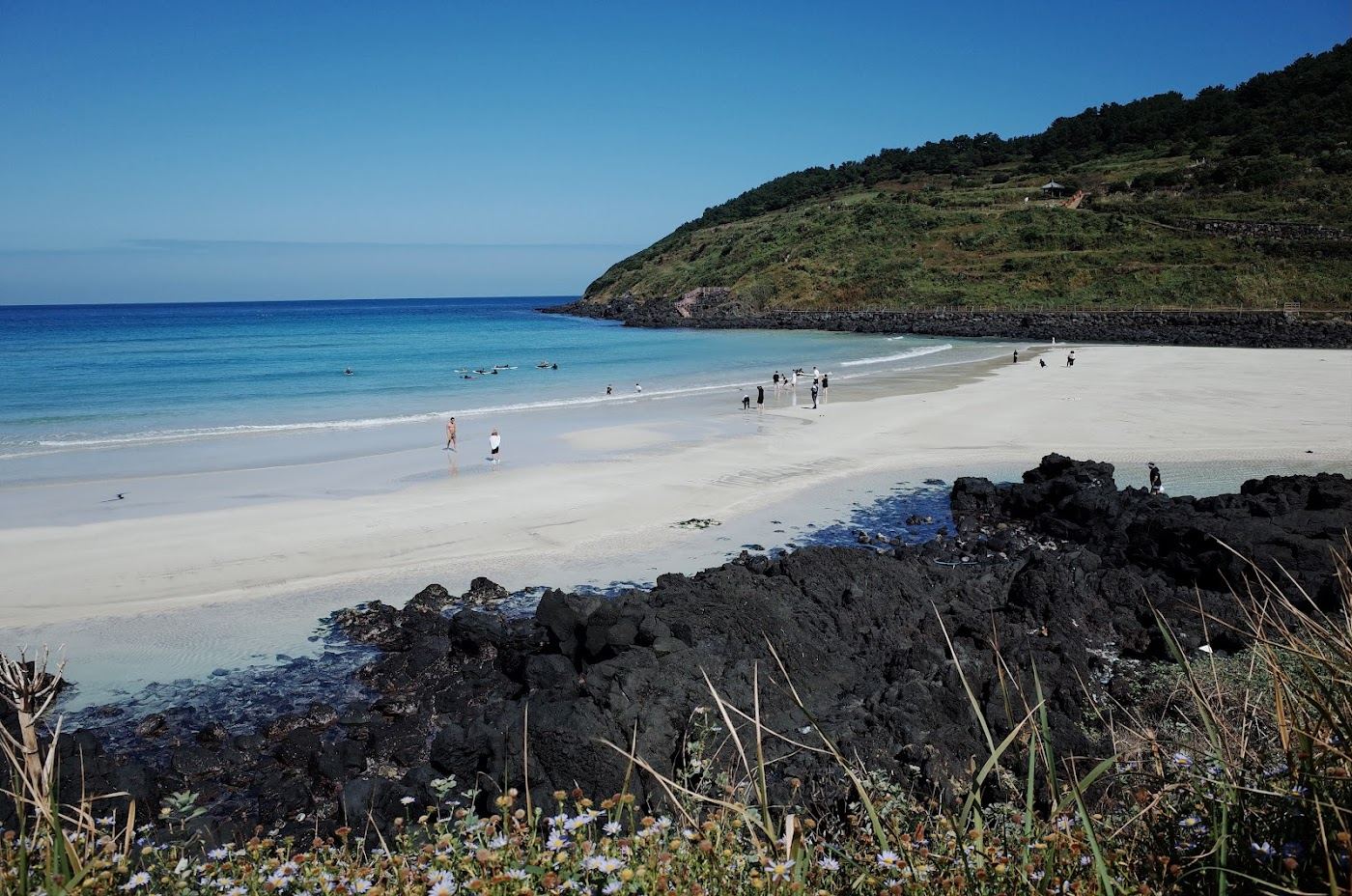Shallow turquoise water and white sand at a calm family beach on Jeju Island