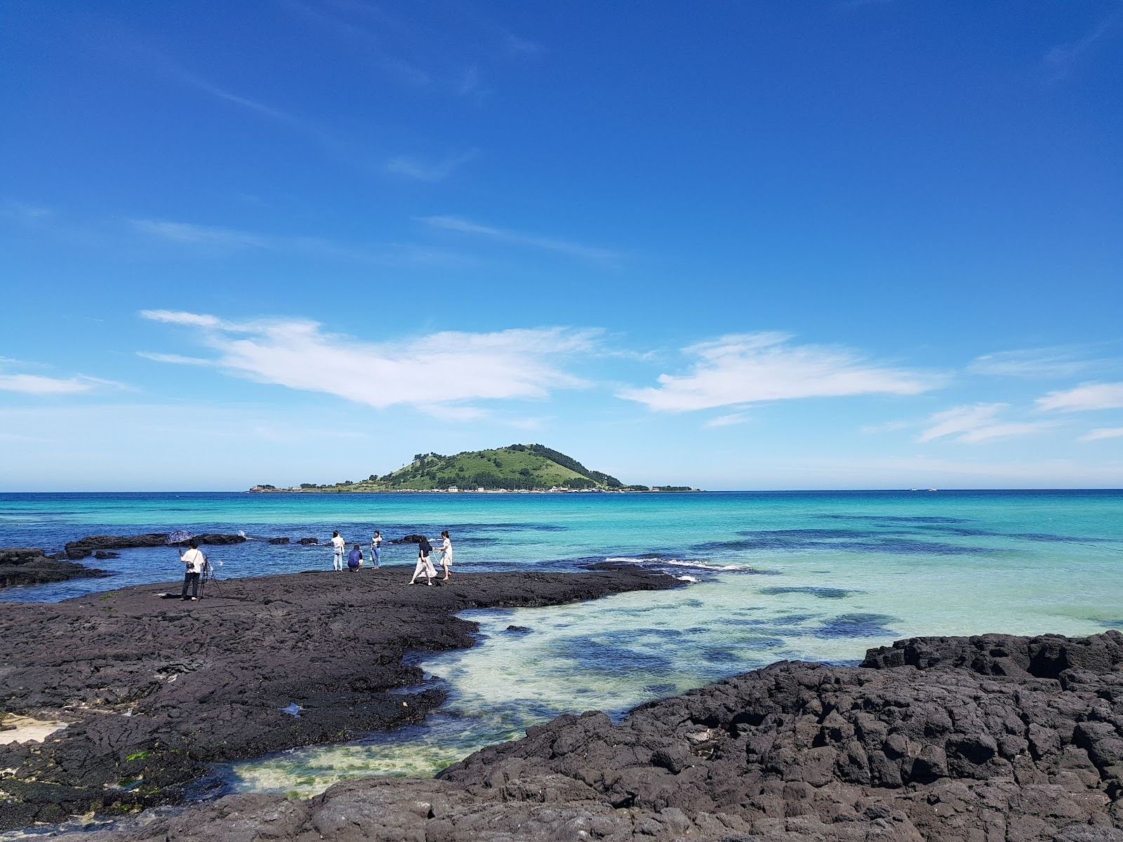 Clear turquoise shallows and white shell sand at Hyeopjae Beach on the west coast of Jeju