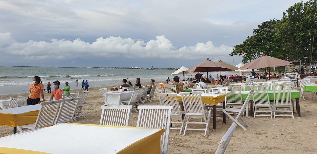 Tables and grilled seafood on the sand at Menega Cafe in Jimbaran Bali