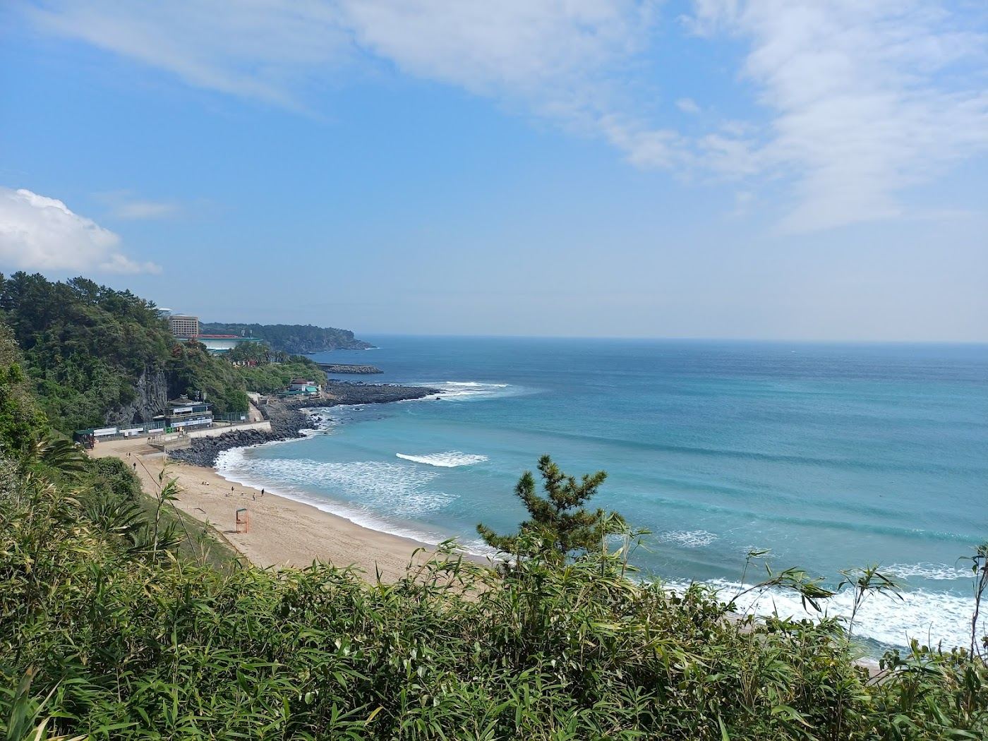 Surf and colored volcanic sand at Jungmun Saekdal Beach on the south coast of Jeju Island