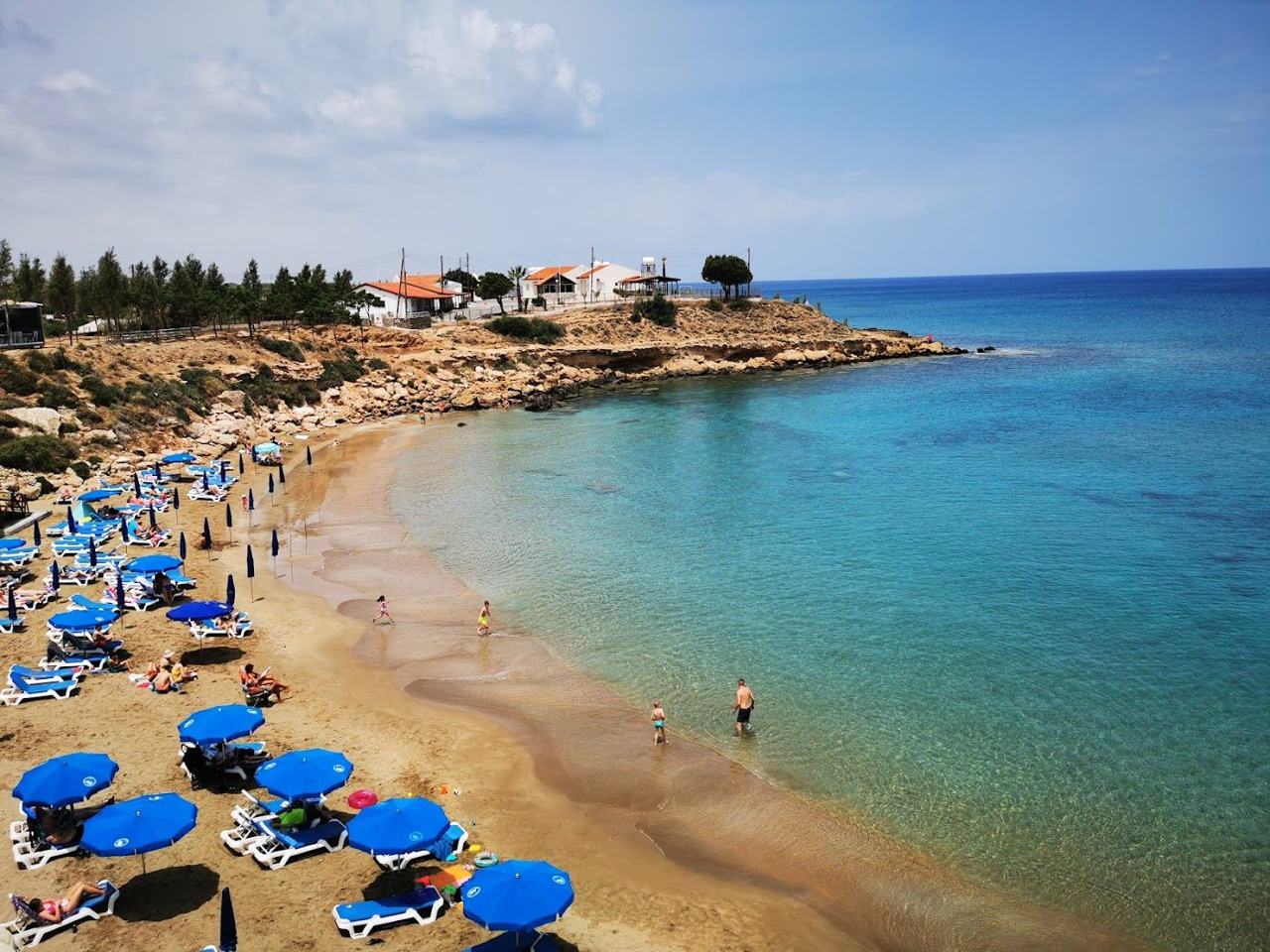 Small sandy cove with shallow clear water and low rocks at Kapparis north of Protaras in Cyprus