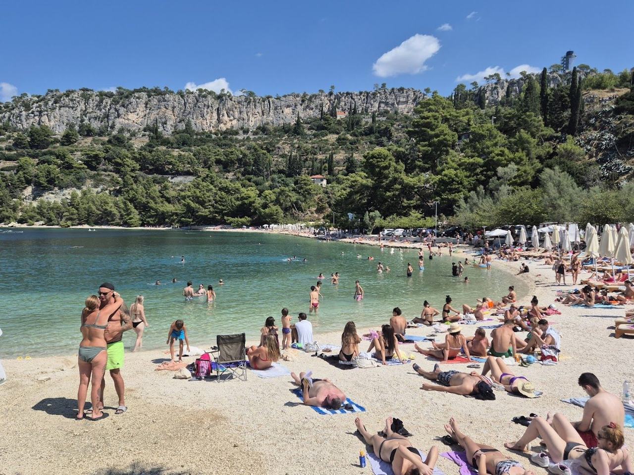 Kasjuni pebble beach below the wooded Marjan hill in Split with clear water on the Dalmatian Coast