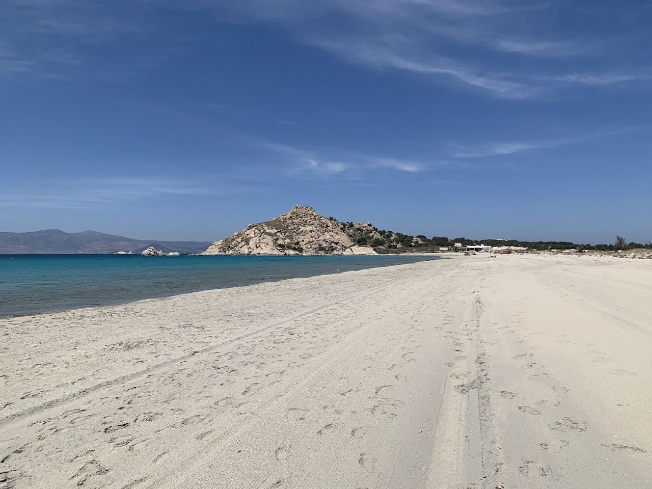The open white sand and clear calm water of Kastraki beach in Naxos