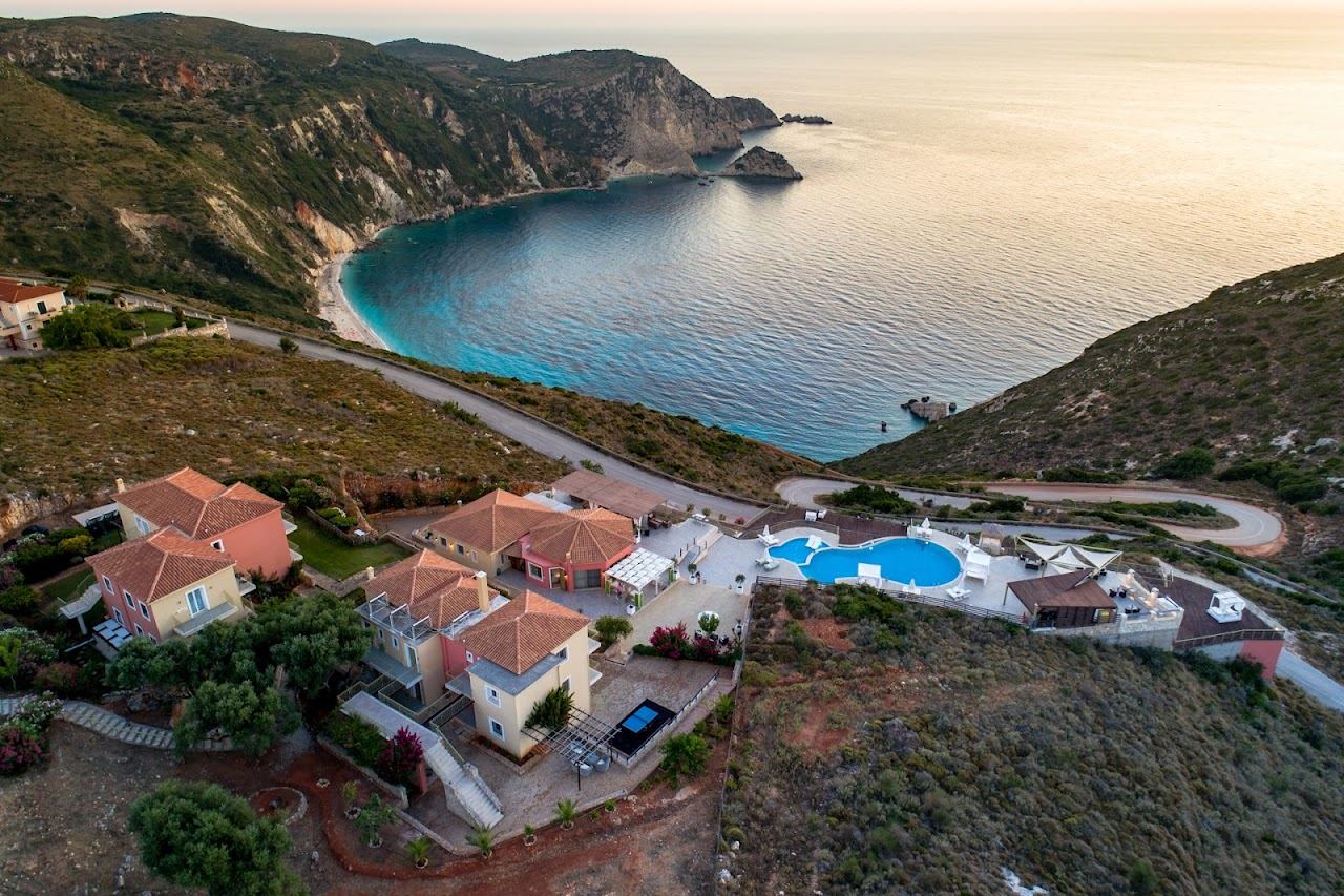 The white pebbles and blue water of Petani Beach below cliffs on the Paliki peninsula of Kefalonia