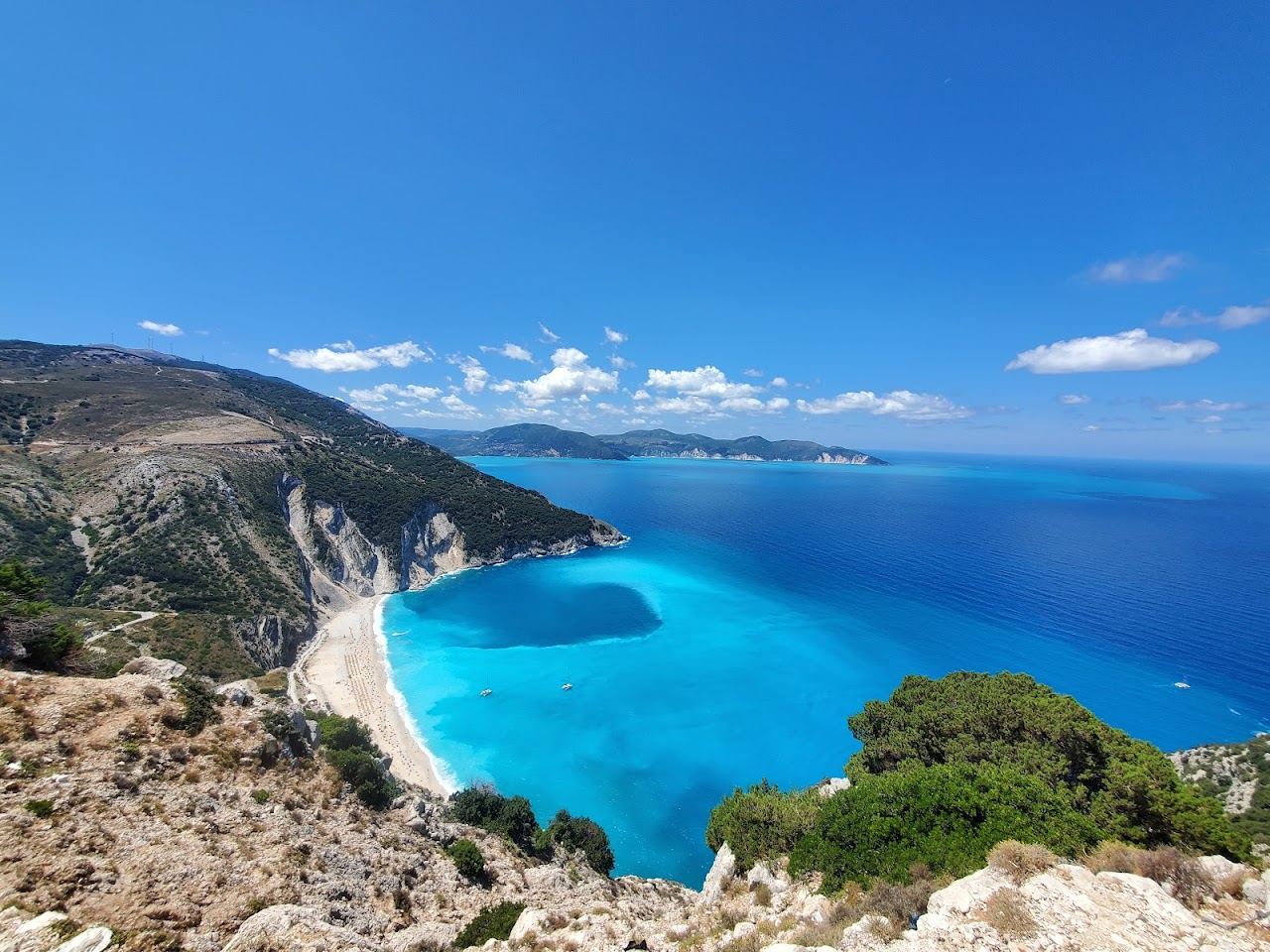 The cliffs and blue Ionian water of the Kefalonia coast on a clear summer day