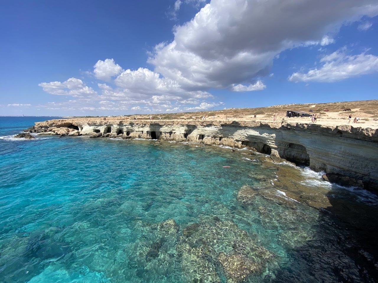Sheltered cove of clear turquoise water framed by pine clad hills at Konnos Bay inside the Cape Greco park in Cyprus