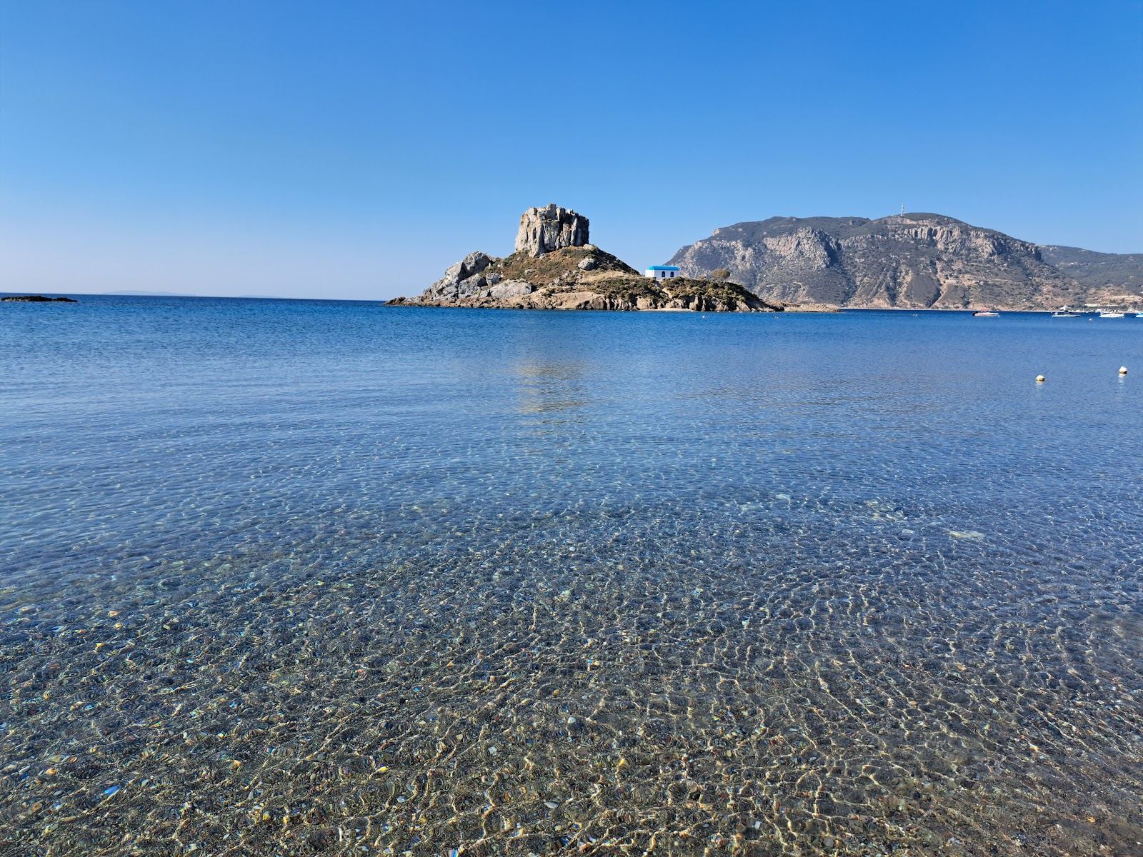 Calm clear water at Agios Stefanos with the small Kastri islet and its chapel offshore on Kos