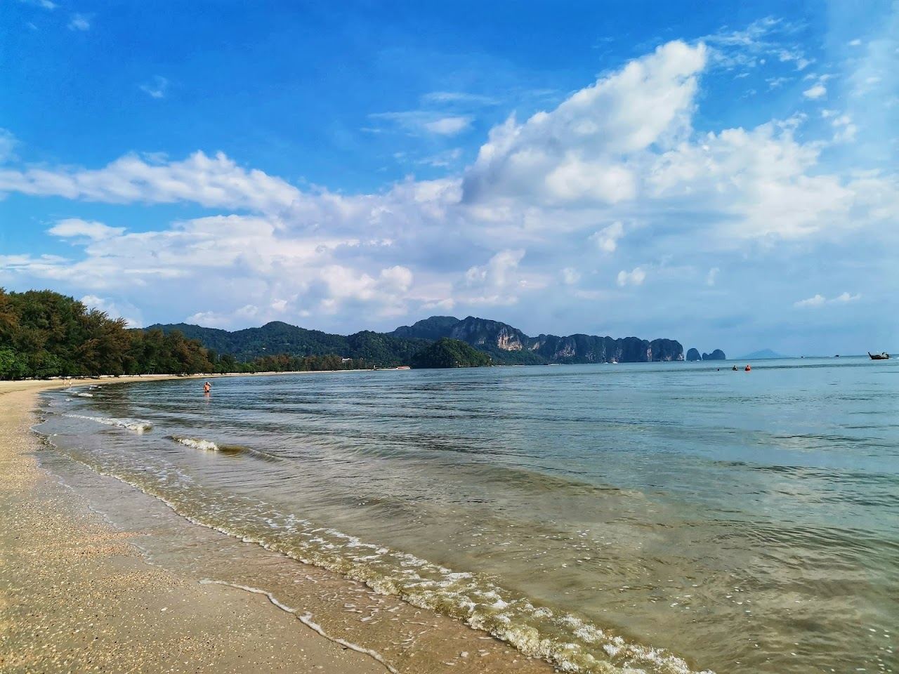 Long quiet sand backed by casuarina pines with small islands offshore at Noppharat Thara beach in Krabi