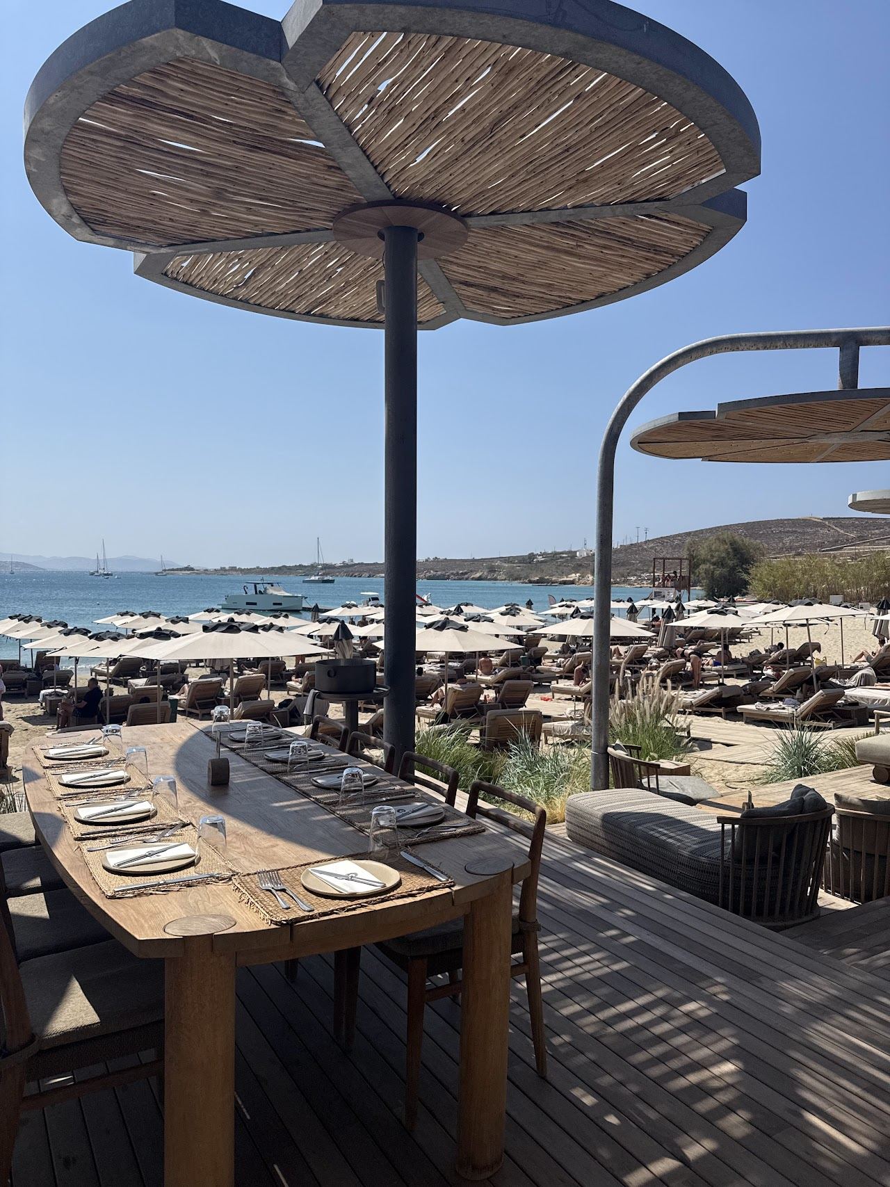 The quiet sand and calm shallow water of Krios beach looking back across the bay to Parikia on Paros