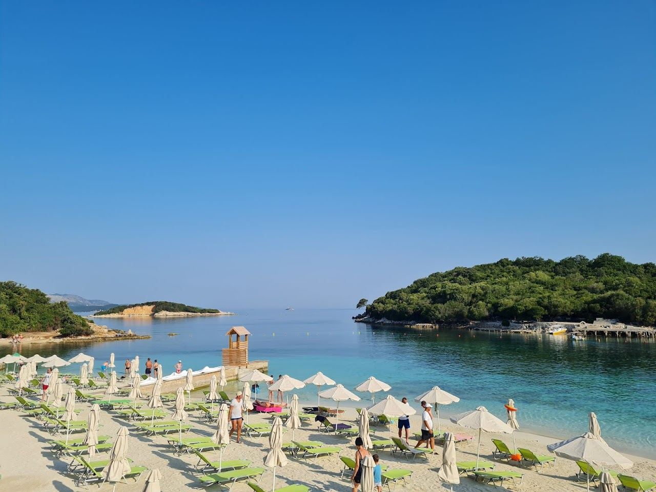 Clear turquoise water and offshore islets seen from the shore at Ksamil