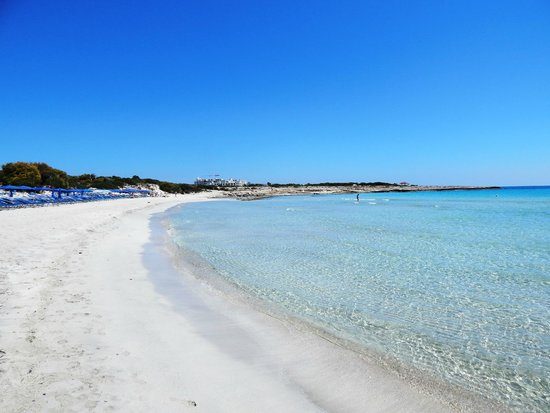 Small soft sand bay with calm shallow turquoise water backed by hotels at Landa beach near Ayia Napa Cyprus