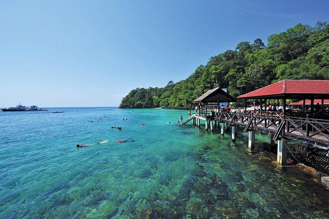Snorkellers in clear water over the reef at Pulau Payar Marine Park near Langkawi