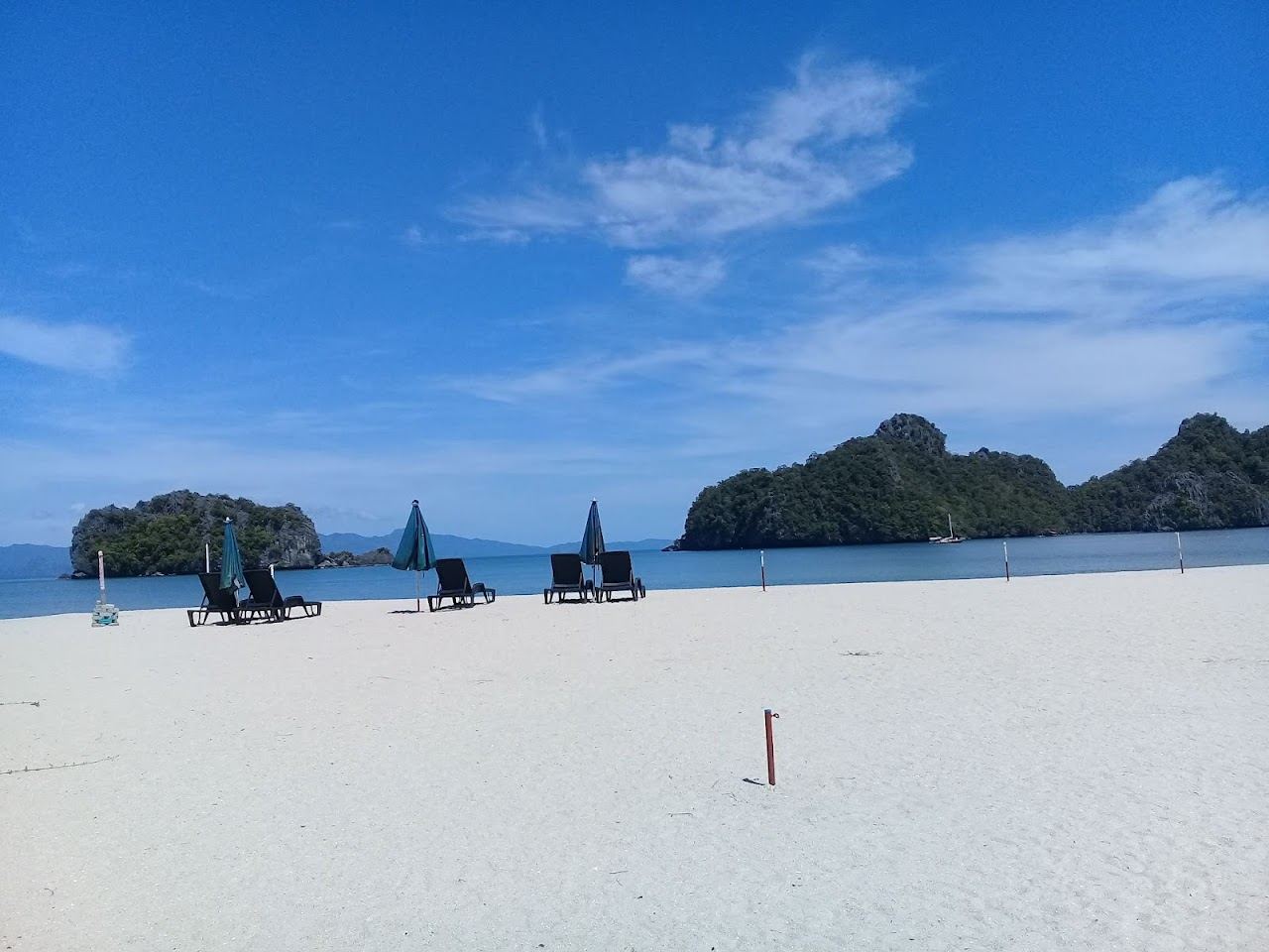 Calm clear water and pale sand framed by limestone karsts at Tanjung Rhu in northern Langkawi