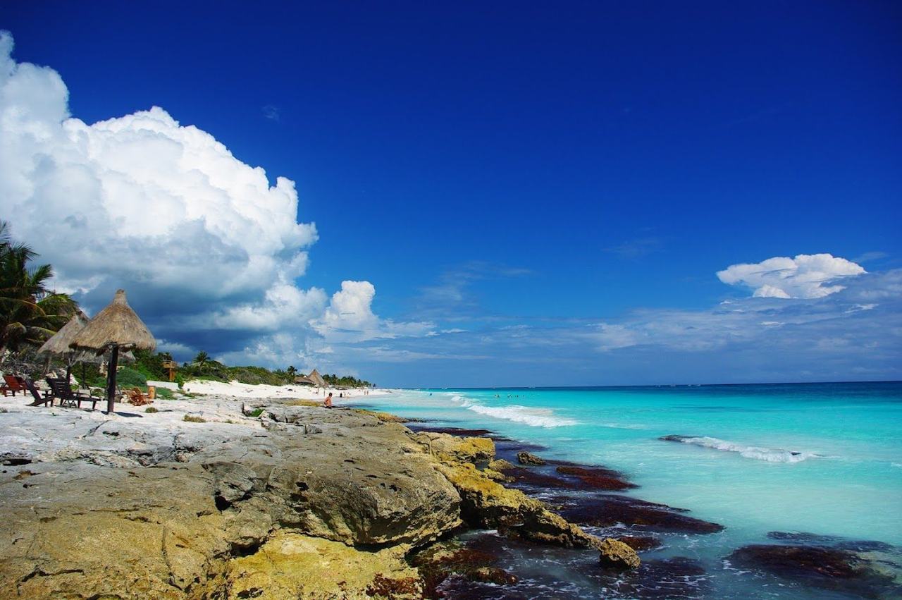 Wide quiet white sand and open Caribbean water at Las Palmas public beach in Tulum
