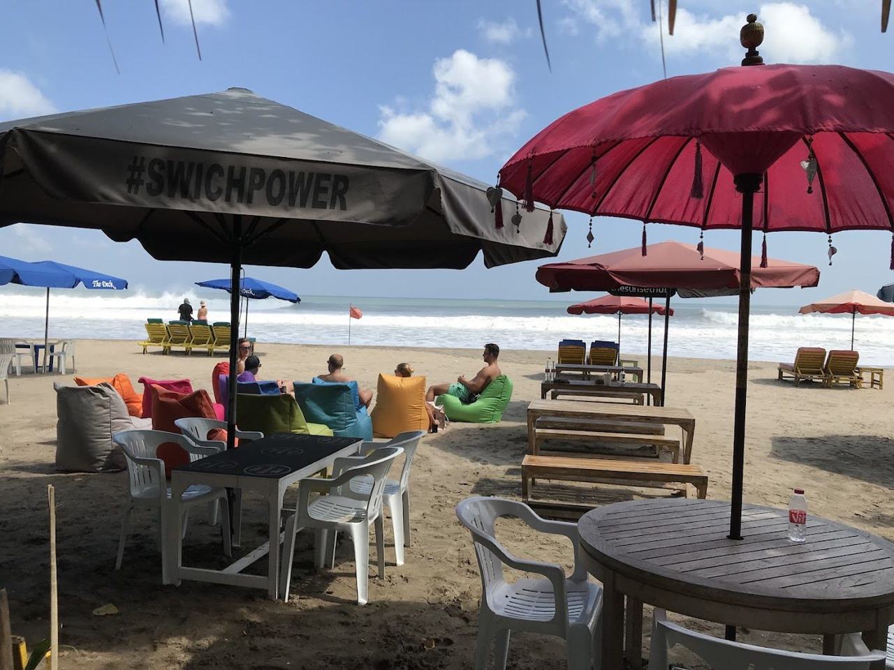 Wide golden sand and surf at Legian Beach in Bali at sunset