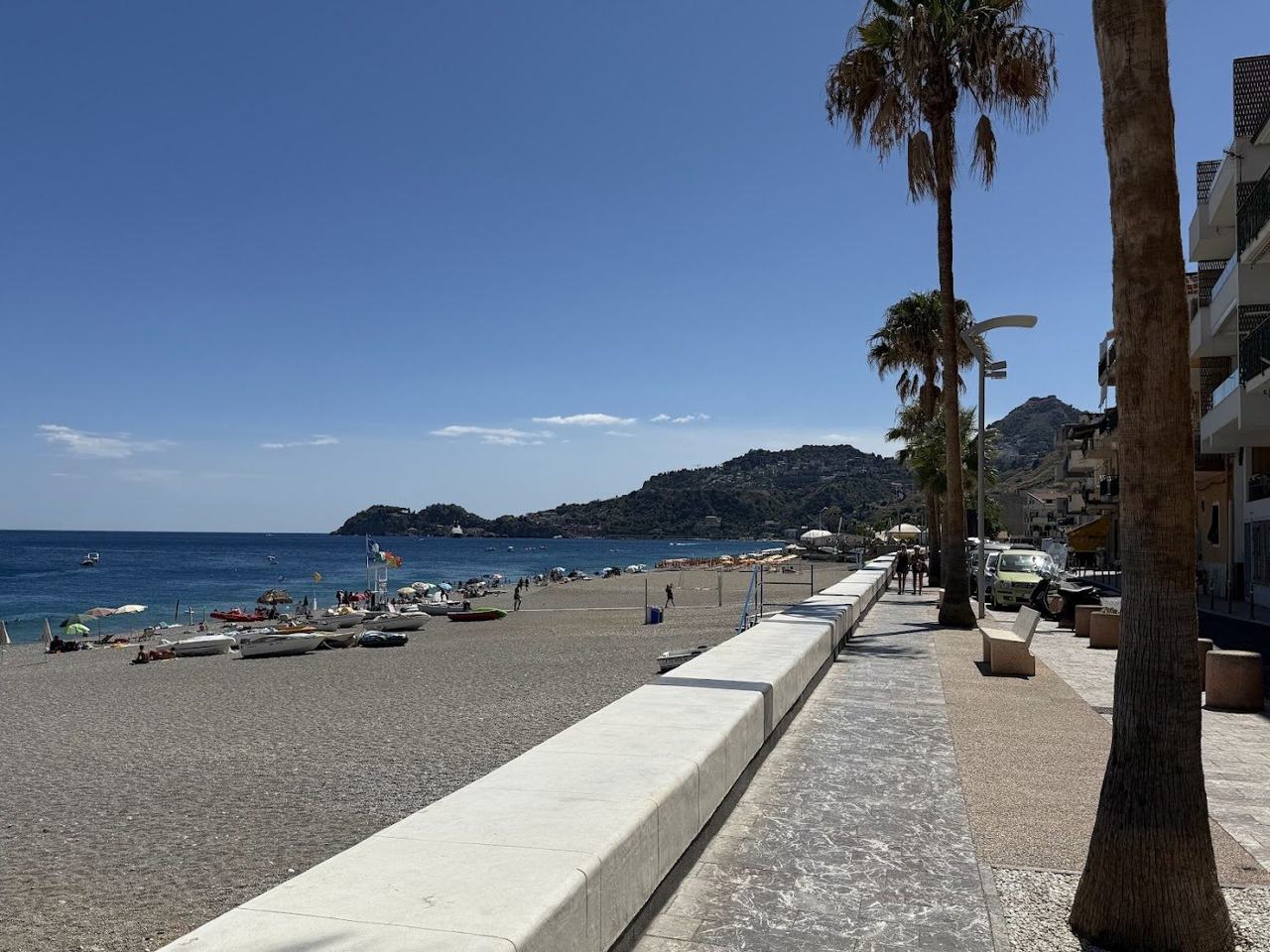 Sand and shingle beach with lidos and clear water at Letojanni below Taormina Sicily