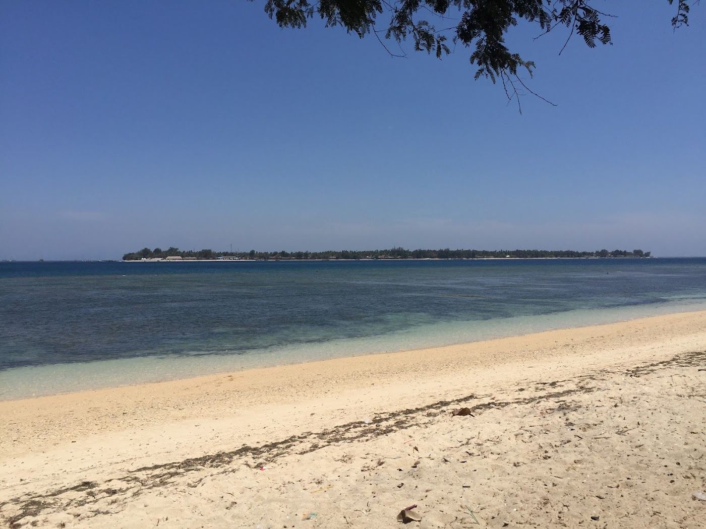 Long white sand and calm shallow water at Sira Beach on the north coast of Lombok