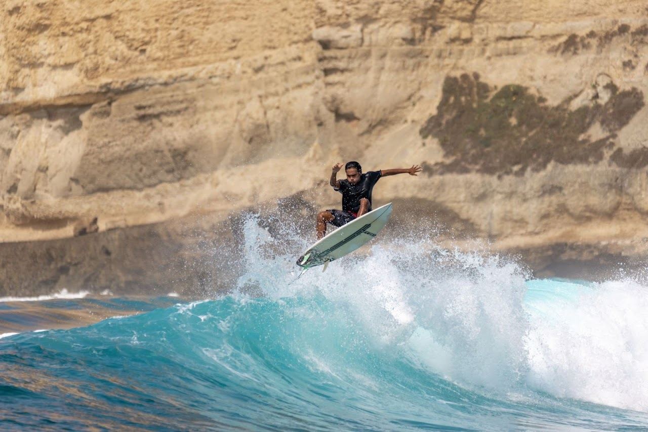 Surfers riding a break in a sheltered bay on the south coast of Lombok near Kuta