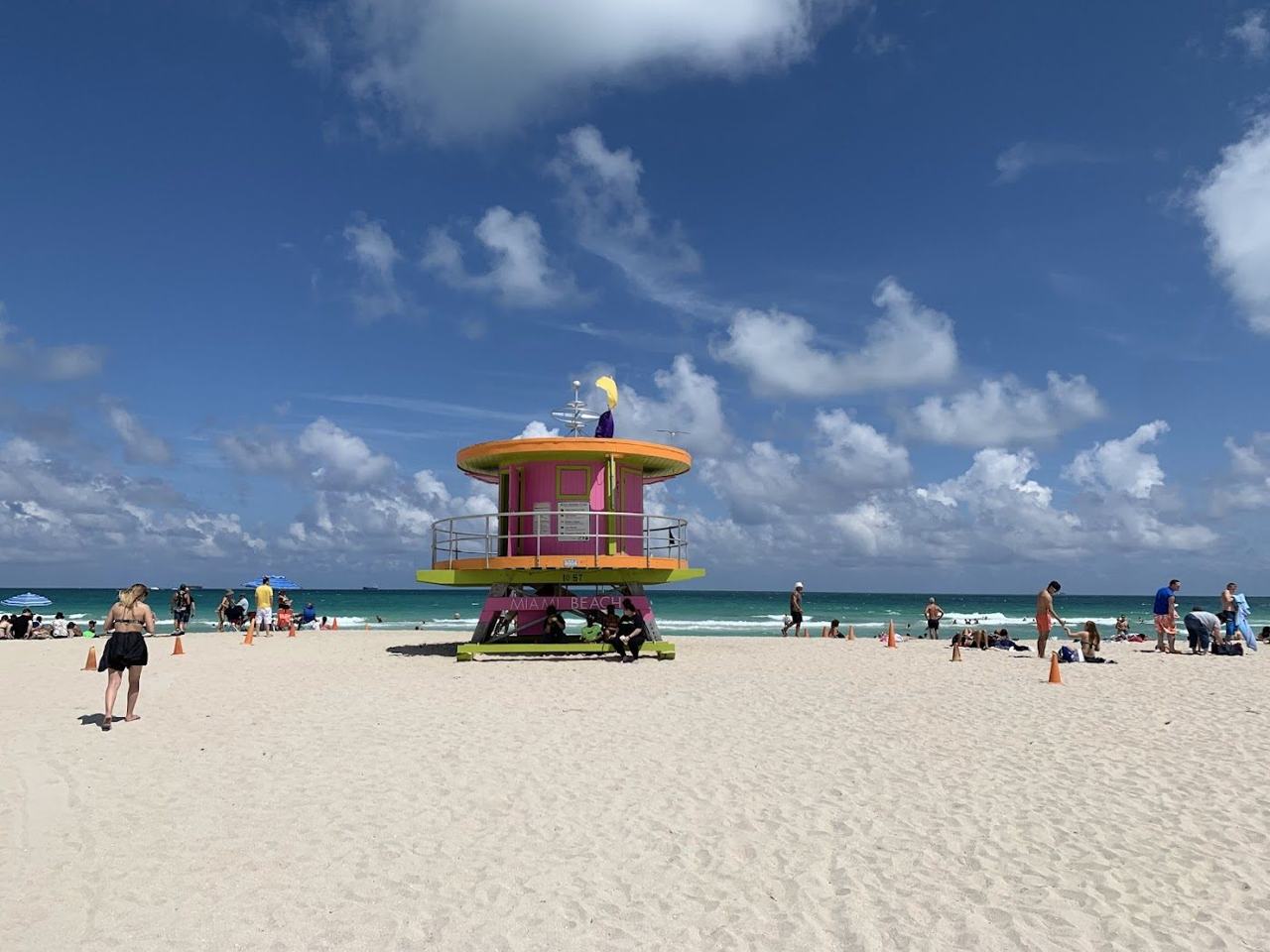 Lummus Park Beach Miami wide pale sand and colourful lifeguard towers backed by the palm lawn and Art Deco hotels of Ocean Drive