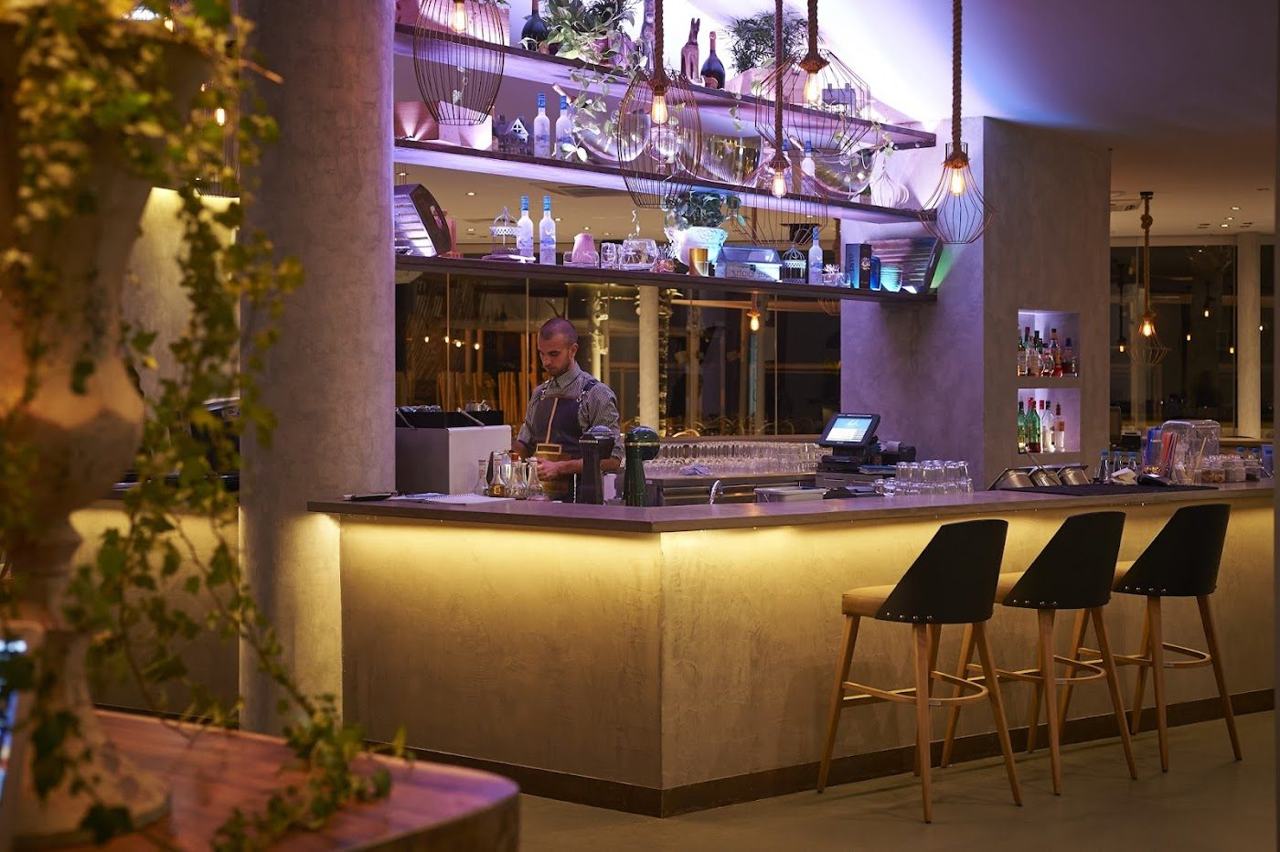 Sandy town beach with sunbeds and a row of beach bars and restaurants at Mackenzie in Larnaca Cyprus