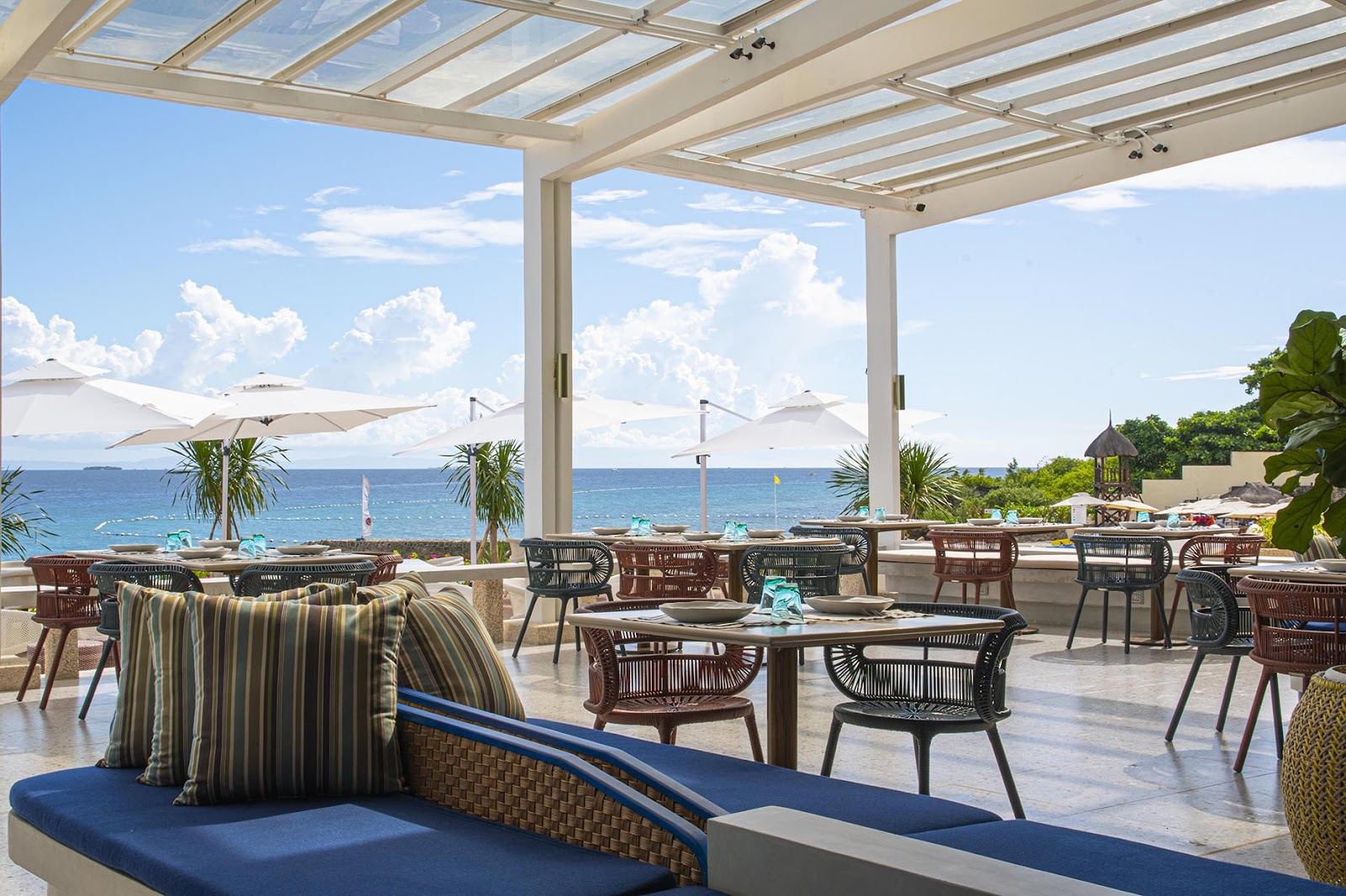 Infinity pool and sunbeds overlooking the calm Mactan Channel at a beach club on Mactan Island