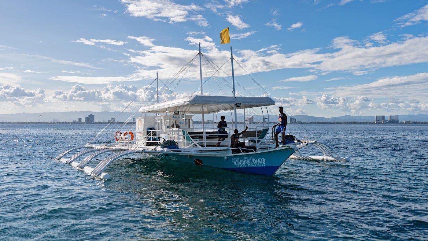 Island hopping boat and snorkellers over a reef in clear water off Mactan Island in Cebu Philippines
