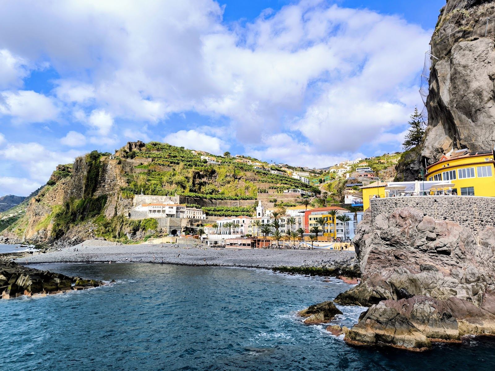 Evening light over the pebble beach and pier at Ponta do Sol on the southwest coast of Madeira
