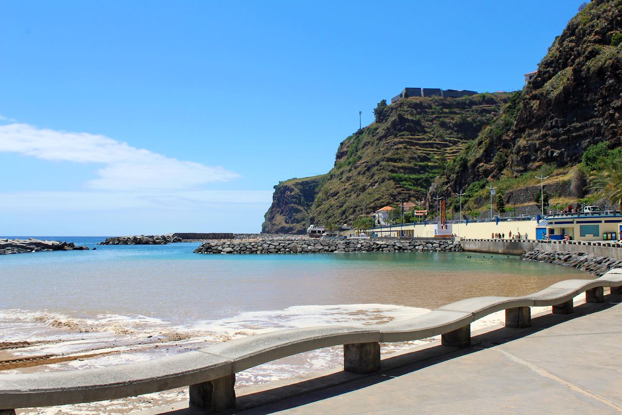 Golden sand and calm sheltered water at the man made beach of Calheta on the sunny southwest coast of Madeira